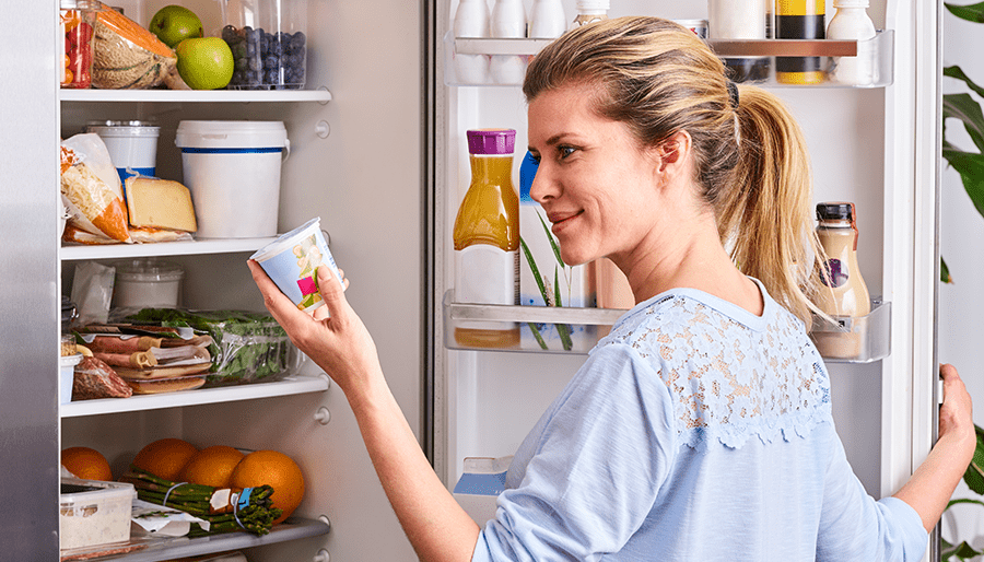 woman looking at food in fridge
